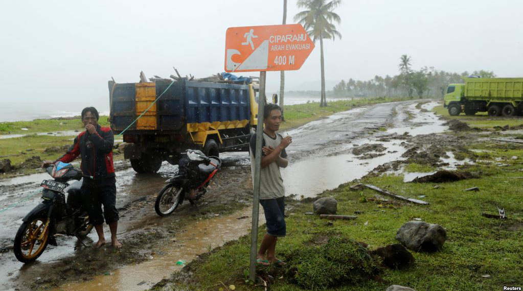 Beberapa pria di tengah hujan di kecamatan Sumur, Provinsi Banten, yang terdampak tsunami, 26 Desember 2018. (Foto: Reuters)