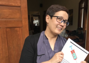 Peneliti Intuisi Inc, Ingrid Irawati Atmosukarto, memegang hasil kajian terhadap pendekatan perang terhadap narkoba. ia mengusulkan pendekatan pengurangan dampak buruk atau "harm reduction". (Foto: Rio Tuasikal/VOA)