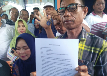 Awan Hasan pemilik lahan pekuburan keluarga, saat memberikan pernyataan tertulis, Minggu (13/1/2019). Dirinya menyatakan tidak pernah meminta Sarco Pomontolo bersama keluarga untuk memindahkan makam. Foto: Lukman Polimengo.