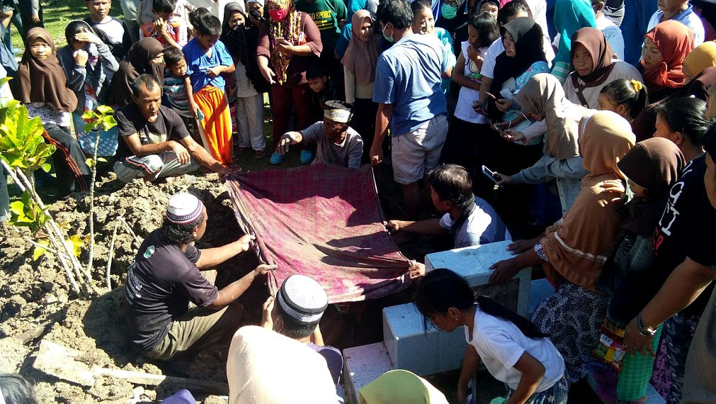 Proses pembongkaran makam dari Masri Dunggio dan Siti Aisyah Hamza, di Desa Toto Selatan, kecamatan Kabila, Sabtu (12/11/2019). kedua makam dipindahkan lantaran keluarga tak mendukung salah satu Caleg. foto: Lukman Polimengo.