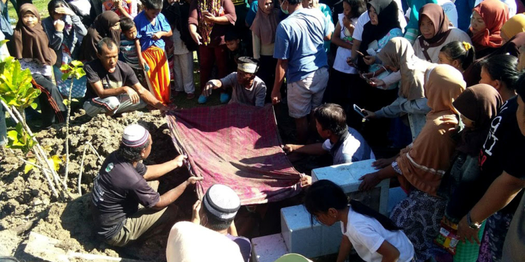 Proses pembongkaran makam dari Masri Dunggio dan Siti Aisyah Hamza, di Desa Toto Selatan, kecamatan Kabila, Sabtu (12/11/2019). kedua makam dipindahkan lantaran keluarga tak mendukung salah satu Caleg. foto: Lukman Polimengo.
