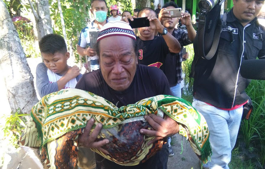 Tak mendukung salah satu Caleg, Pihak keluarga membongkar dan memindahkan makam Siti Aisyah Hamzah dan Masri Dunggio, Sabtu (12/1/2019). Foto: Lukman Polimengo.