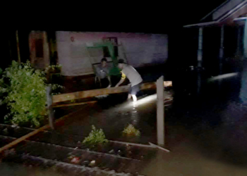 Anggota Bhabinkamtibmas Desa Wonggarasi terjun langsung memantau banjir yang terjadi di Dusun Potanga, Desa Wonggarasi, Kecamatan Lemito, Sabtu (2/2/2019). Foto: AKP Meidi Wuisan.