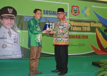 Bupati Gorontalo, Nelson Pomalingo saat menerima cendramata dari Wakil Bupati Bolaang Mongondow Utara, Amin Lasena.