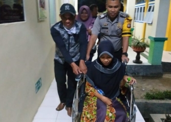 Bripka Saiful, Bhabinkamtibmas di Polsek Bolango, saat membantu warga binaannya yang sakit.