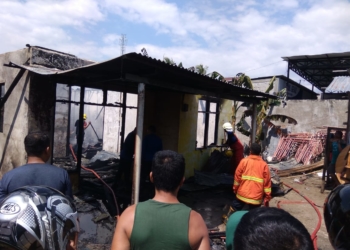 Petugas pemadam kebakaran memadamkan kobaran api yang membakar rumah Roni H Bumolo, salah seorang caleg di Kelurahan Moodu, Kecamatan Kota Timur, Kota Gorontalo, Senin (19/3/2019). (FOTO: ANDI/gopos.id)