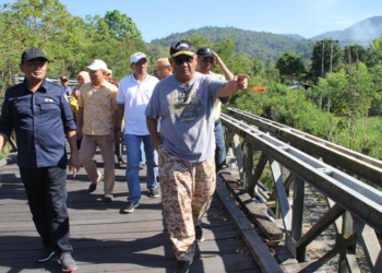 Gubernur Gorontalo, Rusli Habibie (kanan) didampingi Kadis PUPR Handoyo (kiri) saat meninjau jembatan Molintogupo yang menghubungkan Kecamatan Suwawa dan Suwawa Selatan, Minggu (7/04/2019). (Foto - Humas Pemprov).
