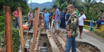 Sejumlah warga bergotong royong membuat jembatan darurat berbahan batang kelapa, pasca jembatan Tolomato yang menghubungkan Kecamatan Suwawa Tengah dan Suwawa Timur ambruk akibat diterjang banjir beberapa waktu yang lalu. Jembatan Tolomato salah satu infrastruktur yang menjadi kewenangan provinsi yang ada di Bone Bolango. (F.dok.AKP)