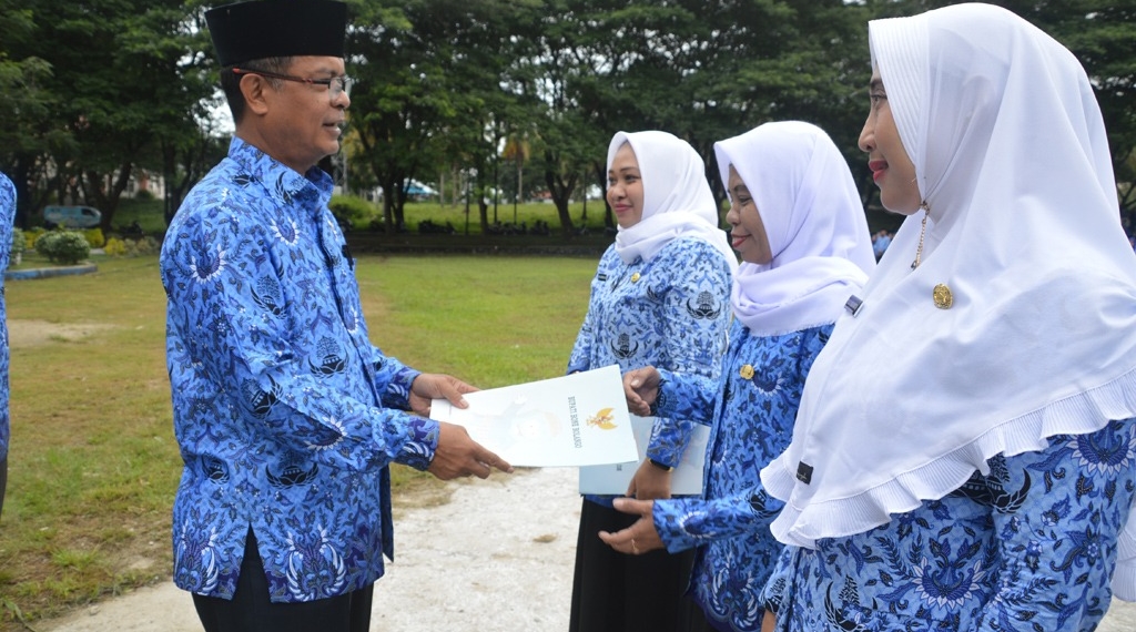 Sekda Ishak Ntoma menyerahkan SK Bupati Bone Bolango kepada 3 orang CPNS formasi dari program PTT Kemenkes tahun 2019 di lingkungan Pemerintah Kabupaten Bone Bolango, pada apel Korpri di halaman Kantor Bupati Bone Bolango, Senin (17/6/2019). (Foto:.AKP)