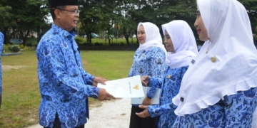 Sekda Ishak Ntoma menyerahkan SK Bupati Bone Bolango kepada 3 orang CPNS formasi dari program PTT Kemenkes tahun 2019 di lingkungan Pemerintah Kabupaten Bone Bolango, pada apel Korpri di halaman Kantor Bupati Bone Bolango, Senin (17/6/2019). (Foto:.AKP)