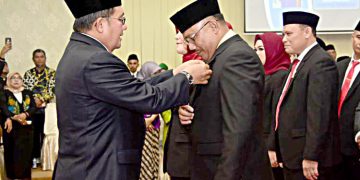 Wali Kota Gorontalo Marten Taha, saat menyematkan pin anggota DPRD Kota Gorontalo, kepada Risman Taha, Anggota DPRD Kota Gorontalo terpilih, periode tahun 2019-2024.