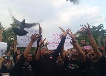Aksi unjuk rasa Aliansi Jurnalis Gorontalo melepas burung merpati di depan gerbang kampus Universitas Negeri Gorontalo.