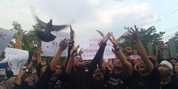 Aksi unjuk rasa Aliansi Jurnalis Gorontalo melepas burung merpati di depan gerbang kampus Universitas Negeri Gorontalo.