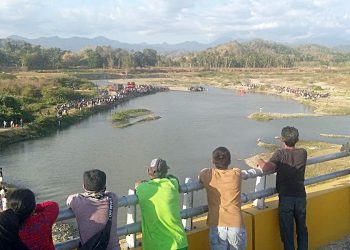 Warga menyaksikan proses evakuasi korban tenggelam di Sungai Bone, Kabupaten Gorontalo. Lokasi ini juga merupakan lokasi aktvitas penambangan galian C. Foto: Lukman Polimengo.