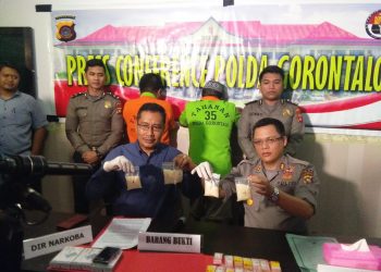 Dir Narkoba Polda Gorontalo, Kombes Pol Dewa Putu Gede Arta (baju biru) bersama Kabid Humas Polda Gorontalo, AKBP Wahyu Tri Cahyono, saat memperlihatkan barang bukti narkoba jenis sabu. Barang bukti sabu ini merupakan hasil pengungkapan kasus yang melibatkan seorang warga binaan di Lapas kelas II A Manado, Sulawesi Utara. Foto: Lukman Polimengo.