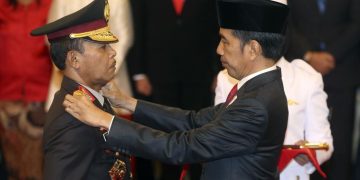 Kepala Kepolisian Republik Indonesia Baru Jenderal Idham Aziz (kiri), menerima lencana baru dari Presiden Indonesia Joko Widodo (kanan), dalam upacara pengambilan sumpah jabatan di Istana Negara, Jakarta, Jumat, 1 November 2019. (AP Foto / Achmad Ibrahim)