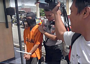 tersangka pelaku pencurian kotak amal, saat di giring ke Mapolres Gorontalo Kota.