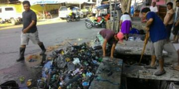 Petugas kebersihan DLH Kota Gorontalo dan Tim Gagah Dinas PUPR Kota Gorontalo, ketika memberishkan saluran yang tersumbat oleh sampah.