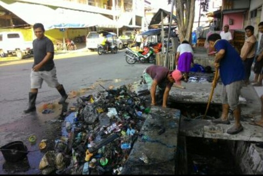 Petugas kebersihan DLH Kota Gorontalo dan Tim Gagah Dinas PUPR Kota Gorontalo, ketika memberishkan saluran yang tersumbat oleh sampah.