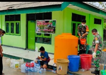 Pembagian cairan desinfektan oleh personil Koramil Tibawa.