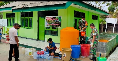 Pembagian cairan desinfektan oleh personil Koramil Tibawa.