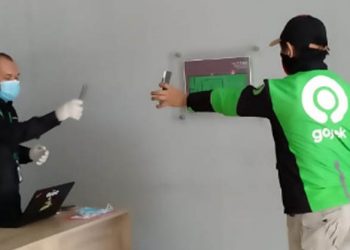 Salah seorang mitra Gojek menerima bantuan masker dan vitamin.