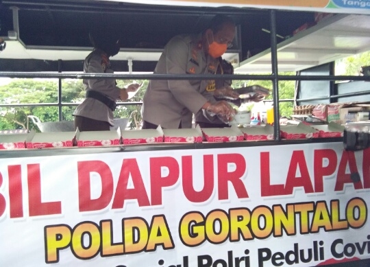 Kapolda Gorontalo, Brigjen Pol. Adnas saat menyiapkan makanan yang nantinya akan diberikan kepada warga terdampak Covid  19. Foto: Lukman Polimengo.