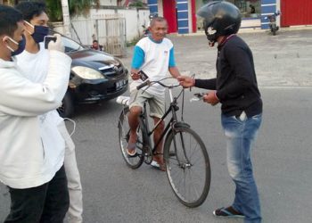 Komunitas Panitia 9, saat membagikan masker kepada warga yang melintas di Bundaran Saronde, Kota Gorontalo. Foto: Lukman Polimengo.