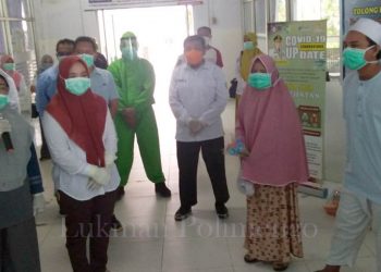 Proses penyerahan dua pasien positif corona yang dinyatakan sembuh dari Covid 19. Foto: Lukman Polimengo.