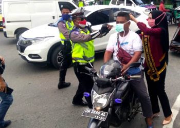 Dalam rangka memperingati Hari Kartini tahun 2020, Kepolisian Daerah (Polda) Gorontalo mengadakan kegiatan bagi-bagi masker serta himbauan kepada masyarakat, yang digelar di Bundaran Saronde, Kota Gorontalo, Rabu (22/4/2020). Foto: Lukman Polimengo.