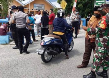 Aparat kepolisian dan TNI saat melakukan pengawalan terhadap warga yang mendatangi Kantor Desa Tunggulo. Foto: Istimewa.