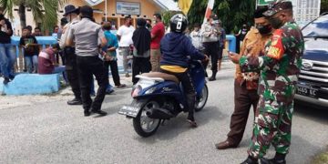 Aparat kepolisian dan TNI saat melakukan pengawalan terhadap warga yang mendatangi Kantor Desa Tunggulo. Foto: Istimewa.