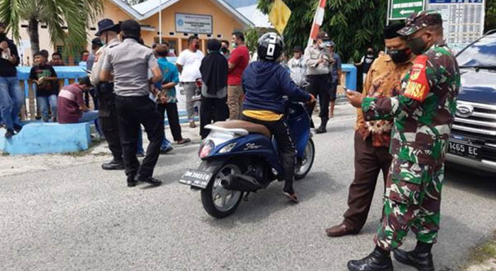 Aparat kepolisian dan TNI saat melakukan pengawalan terhadap warga yang mendatangi Kantor Desa Tunggulo. Foto: Istimewa.