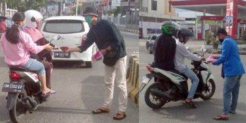 Pengurus wilayah PMII Kota Gorontalo membagi-bagikan masker kepada warga yang melintas di Bundaran Saronde, Kota Gorontalo. Foto: Lukman Polimengo.