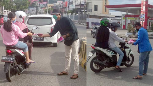 Pengurus wilayah PMII Kota Gorontalo membagi-bagikan masker kepada warga yang melintas di Bundaran Saronde, Kota Gorontalo. Foto: Lukman Polimengo.