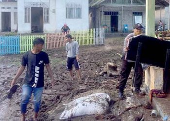 Warga dibantu aparat TNI -Polri, membersihkan sampah dan lumpur yang terbawa air, saat banjir melanda pada Kamis (11/6/2020). Foto Humas Polda Gorontalo.