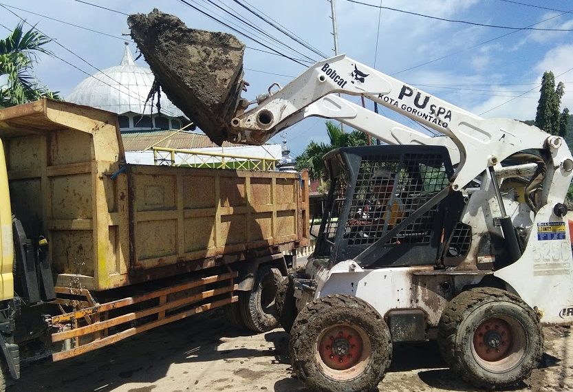 Pemerintah Kota Gorontalo mengerahkan alat berat untuk membantu membersihkan endapan lumpur pasca banjir. Foto: Lukman Polimengo.