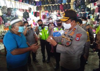 Kapolda Gorontalo Irjen Pol. Adnas saat membagikan masker dan cairan hand sanitizer kepada warga masyarakat yang berada di Pasar Sentral, Kota Gorontalo, Selasa (21/7/2020). Foto: Lukman Polimengo.