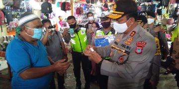 Kapolda Gorontalo Irjen Pol. Adnas saat membagikan masker dan cairan hand sanitizer kepada warga masyarakat yang berada di Pasar Sentral, Kota Gorontalo, Selasa (21/7/2020). Foto: Lukman Polimengo.