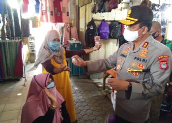Kapolda Gorontalo Irjen Pol. Adnas saat membagikan masker dan cairan hand sanitizer kepada warga masyarakat yang berada di Pasar Sentral, Kota Gorontalo, Selasa (21/7/2020). Foto: Lukman Polimengo.