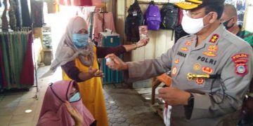 Kapolda Gorontalo Irjen Pol. Adnas saat membagikan masker dan cairan hand sanitizer kepada warga masyarakat yang berada di Pasar Sentral, Kota Gorontalo, Selasa (21/7/2020). Foto: Lukman Polimengo.