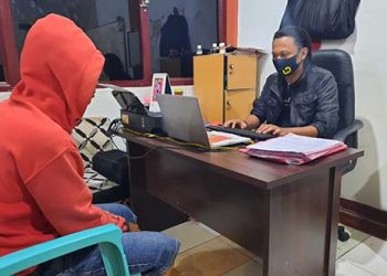 Pelaku penganiayaan (kaos merah) saat menjalani pemeriksaan di Polres Gorontalo Kota.