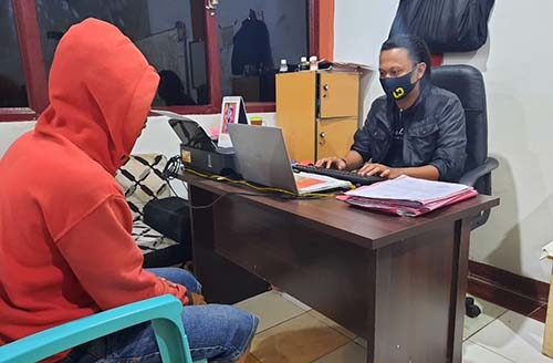 Pelaku penganiayaan (kaos merah) saat menjalani pemeriksaan di Polres Gorontalo Kota.