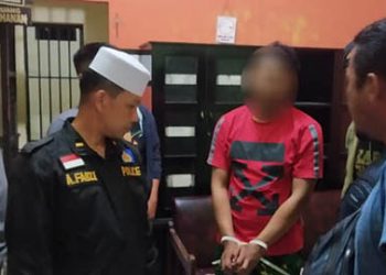 Tersangka pelaku penganiayaan, saat diamankan aparat Polsek Dungingi. Foto: Humas Polda Gorontalo.