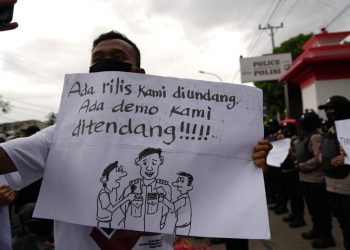 Seorang wartawan membawa poster saat unjuk rasa damai wartawan di depan Mapolda Gorontalo, Kamis (15/10/2020)