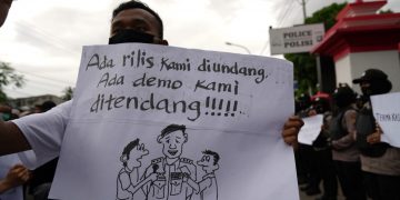 Seorang wartawan membawa poster saat unjuk rasa damai wartawan di depan Mapolda Gorontalo, Kamis (15/10/2020)