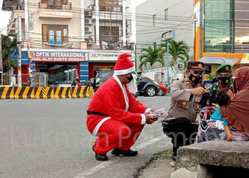 Dalam rangka Operasi Lilin Otanaha 2020, menyambut Hari Natal dan Tahun Baru 2021, jajaran Polres Gorontalo Kota mengadakan kegiatan bagi-bagi masker, dengan mengerahkan personil yang menggunakan kostum Santa Claus. Foto: Lukman Polimengo.