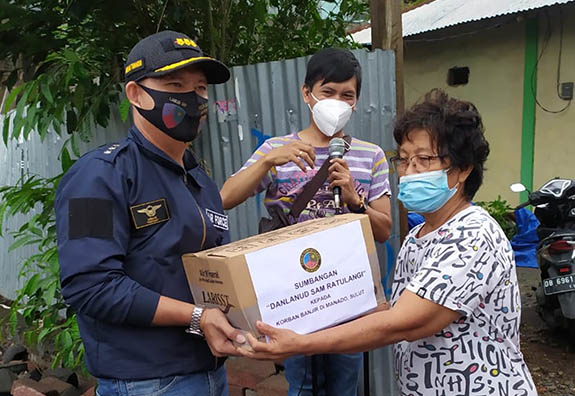 Komandan Pangkalan TNI AU Sam Ratulangi Kolonel Pnb Abram Tumanduk saat menyerahkan bantuan kepada warga terdampak banjir di Kelurahan Pakowa, Kecamatan Wanea, Sabtu (23/1/2021).