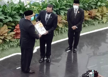Kepala BPK RI, Agung Firman Sampurna (tengah) saat memberikan hasil penilaian kepada Gubernur Gorontalo, Rusli Habibie. dalam Rapat Paripurna DPRD Provinsi Gorontalo, Jumat (11/6/2021) Foto: Lukman Polimengo.