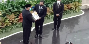 Kepala BPK RI, Agung Firman Sampurna (tengah) saat memberikan hasil penilaian kepada Gubernur Gorontalo, Rusli Habibie. dalam Rapat Paripurna DPRD Provinsi Gorontalo, Jumat (11/6/2021) Foto: Lukman Polimengo.